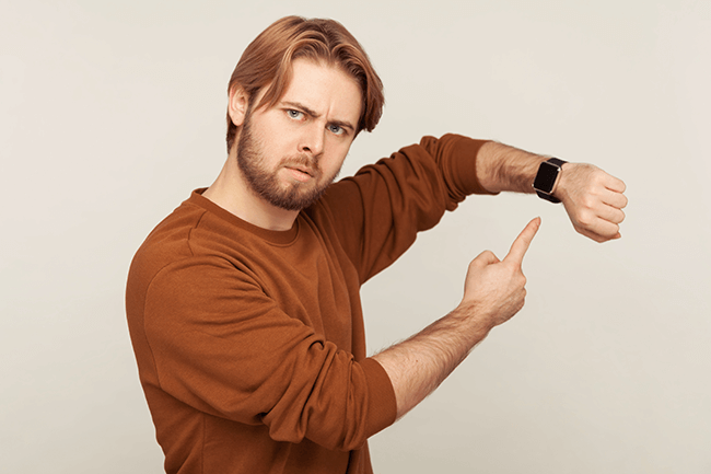 man wijst op horloge